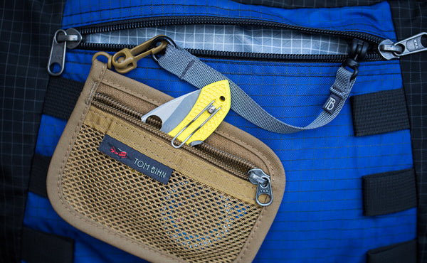 An 8-inch Key Strap with a snaphook at one end and an o-ring at the other attaching a Coyote Mesh Organizer Pouch to the interio pocket of bag.
